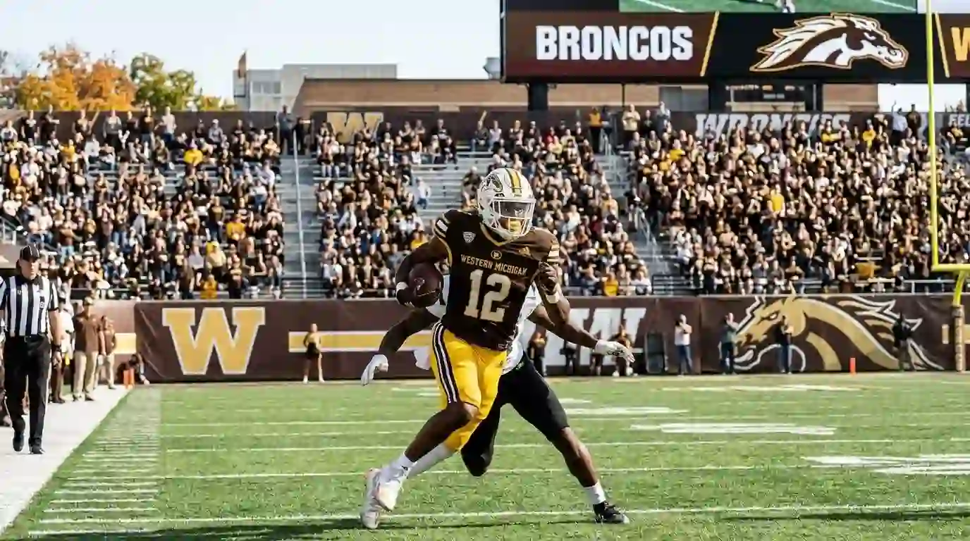 Western Michigan Broncos football player running with the ball at Waldo Stadium during a game